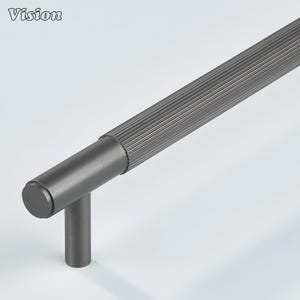 Peut inclure: Une poignée de meuble gris foncé avec une poignée cylindrique et une texture nervurée. La poignée a une base en forme de T et une extrémité arrondie. Le mot "Vision" est dans le coin supérieur gauche.