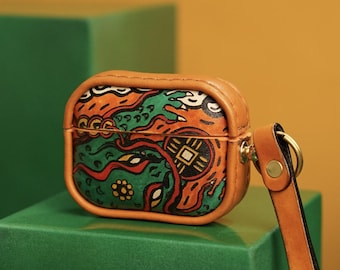 May include: A brown leather Airpods case with a colorful abstract design. The case has a strap with a metal ring.