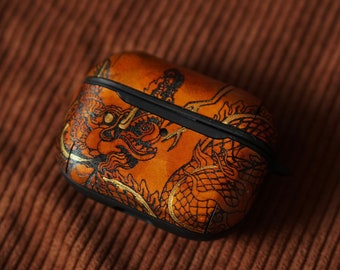 May include: A brown leather Airpods case with a gold dragon design.