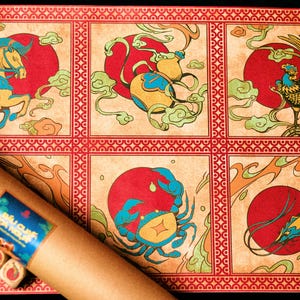 Puede incluir: Una alfombra decorativa con seis paneles que muestran ilustraciones coloridas de animales del zodiaco sobre soles rojos y nubes verdes. Un rollo de papel marrón enrollado con una etiqueta azul y pequeños bloques de madera en primer plano.