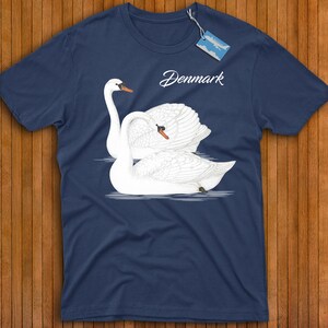 May include: A navy blue t-shirt with a white swan design and the word "Denmark" printed on the front.