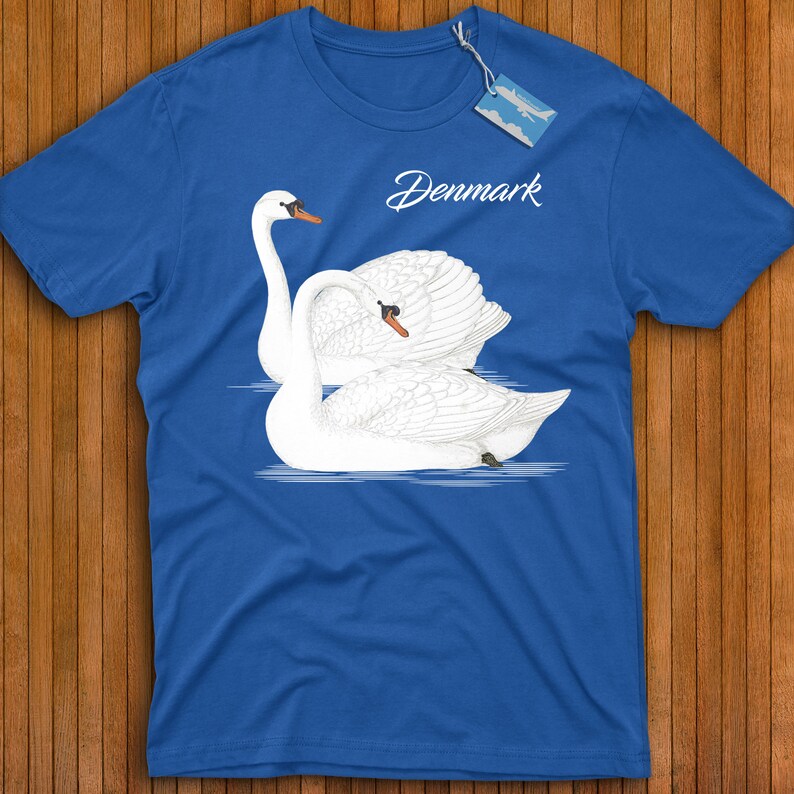 May include: A royal blue t-shirt with a white graphic of two swans on a lake. The text "Denmark" is printed in white on the shirt.