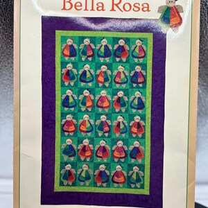 May include: A quilt pattern titled "Bella Rosa" featuring a grid of colorful doll appliqués on a green background, framed by purple and green borders. The text "A Stitch and Split Appliqué design by Bella Nonna" is at the bottom.
