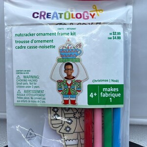 May include: A Creatology nutcracker ornament frame kit in a clear plastic package. The kit includes a wooden frame with a child's image, crayons, and instructions. The package has the text "Christmas | Noël" and "makes 1".