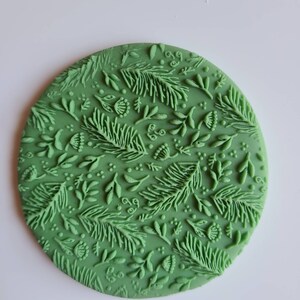 Könnte beinhalten: Grüner Silikon-Kuchen-Dekor-Stempel mit einem sich wiederholenden Muster aus Blättern und Blumen.