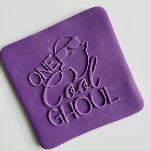 May include: Purple rubber stamp with the text "One Cool Ghoul" and a cartoon ghost wearing sunglasses.