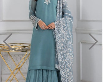 May include: A light blue dress with white embroidery. The dress has a long skirt with a flared bottom and a matching dupatta.