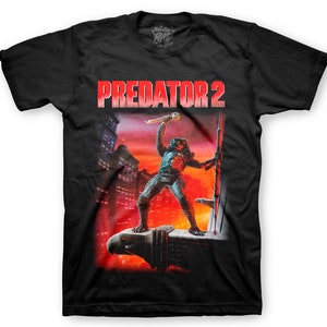 May include: Black t-shirt with a red "Predator 2" title and a graphic of the Predator holding a weapon in a city setting.