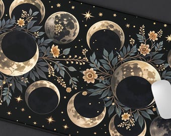 May include: Black rectangular mouse mat with a celestial design featuring phases of the moon, stars, and floral accents. The design includes various moon phases in shades of grey and gold, with a black border.