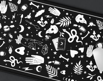 May include: Black and white mouse pad with a design of various mystical and occult symbols, including stars, moons, snakes, and crystals.
