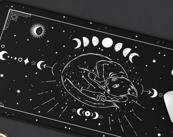 May include: Black mouse pad with a white design of a cat curled up in a circle of moons. The design also includes stars and other celestial symbols.