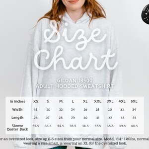 a woman wearing a sweatshirt with the size chart