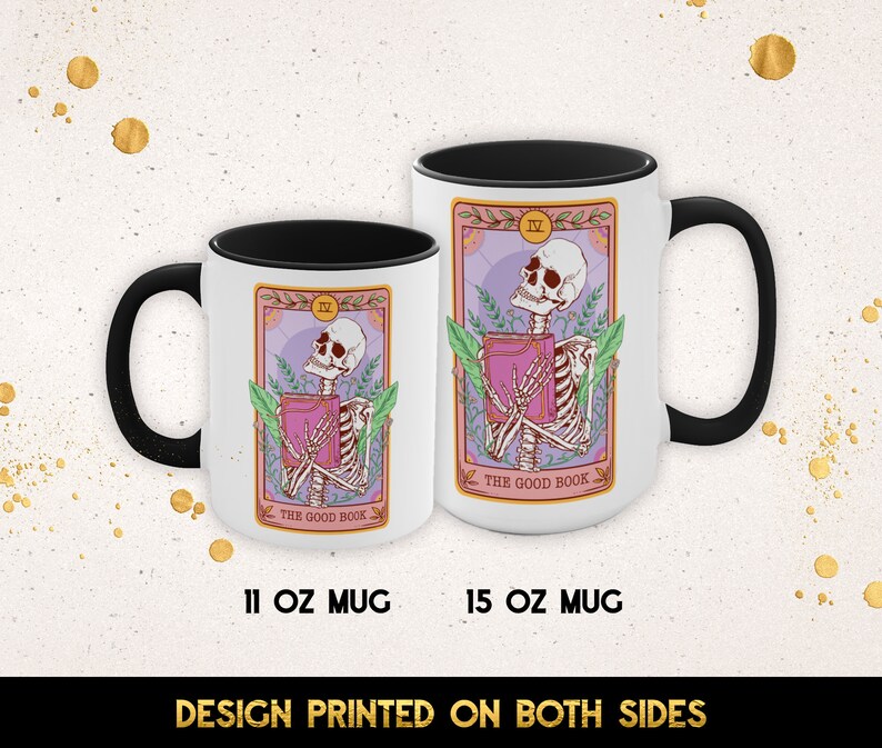 May include: Two white ceramic mugs with black handles. The mugs feature a colorful illustration of a skeleton holding a book with the text "The Good Book" and the Roman numeral "IV". The mugs are available in 11 oz and 15 oz sizes.