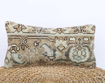 May include: A beige and brown patterned throw pillow with a traditional design. The pillow is made of woven fabric and has a soft, comfortable texture.