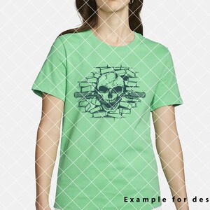 May include: A green t-shirt with a graphic of a skull breaking through a brick wall. The skull is outlined in black and has a menacing expression. The brick wall is also outlined in black.