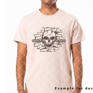 May include: A white t-shirt with a black and white graphic of a skull breaking through a brick wall. The skull has a handlebar mustache and is holding a handlebar.