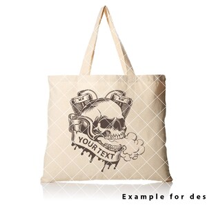 May include: A beige tote bag featuring a black and white illustration of a skull with a motorcycle engine. The text "YOUR TEXT" is on a banner below the skull.
