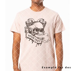 May include: A light pink t-shirt featuring a black and white graphic design of a skull with a smoking engine. The text "YOUR TEXT" is on a banner.
