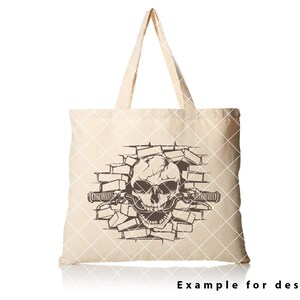 May include: A beige tote bag with a brown skull graphic breaking through a brick wall. The skull has a toothy grin and is holding a handlebar.