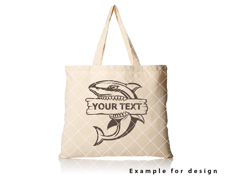 May include: A beige tote bag featuring a brown shark graphic and the text "YOUR TEXT" on a wooden sign. The shark is biting the sign.