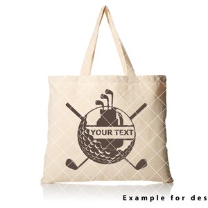 Puede incluir: Una bolsa de lona beige con un dise&ntilde;o de bola de golf marr&oacute;n. La bola de golf tiene una bolsa de golf y palos dentro. El texto "YOUR TEXT" est&aacute; en una pancarta a trav&eacute;s de la bola de golf.