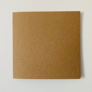 Puede incluir: Un trozo cuadrado de papel kraft marr&oacute;n con una superficie ligeramente texturizada.
