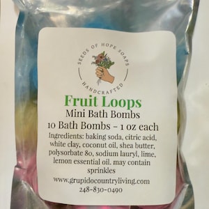 May include: A sealed clear bag containing mini bath bombs in various colours. The label states "Fruit Loops Mini Bath Bombs" and lists ingredients. Each bath bomb weighs approximately 28 grams. The bag is ready for use.