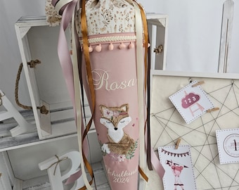 Puede incluir: Un cono escolar rosa con una parte superior estampada floral y cintas. El cono presenta un zorro bordado con el nombre "Rosa" y el texto "Schulkind 2024". El cono está decorado con cintas rosas y doradas.