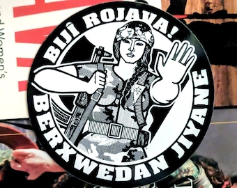 Pegatina de solidaridad con Rojava: ¡Bijî Rojava! Berxwedan Jiyane (¡Larga vida a Rojava! La resistencia es vida), miliciana de las YPJ