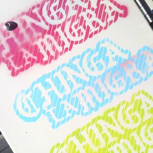 Puede incluir: Superficie blanca con tres dise&ntilde;os de texto coloridos. El dise&ntilde;o superior es rosa, el del medio es azul claro y el inferior es verde. Cada dise&ntilde;o presenta el texto "CHINGA LA MIGRA" en blanco, con un fondo a rayas.