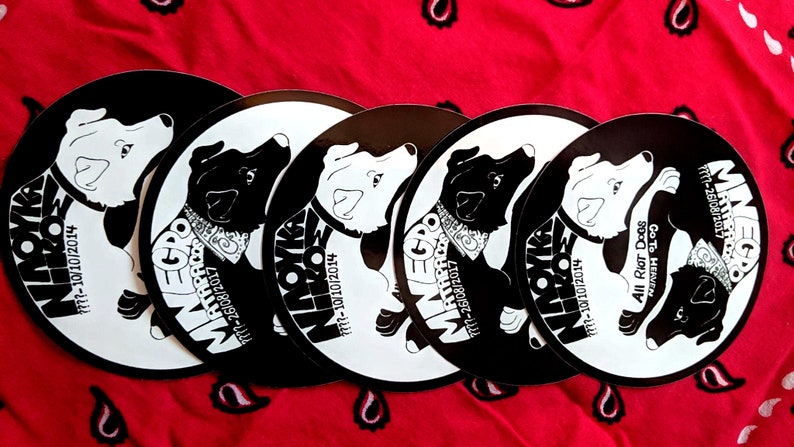May include: Five black and white round stickers with a dog illustration and text. The text on the stickers reads "Minego", "Mathpaco", "All Riot Dogs Go To Heaven", and dates.