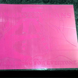 May include: A pink, rectangular sticker with the words "WATCHING JEANS" and "LIVE OFFERING FOR EVERYONE" etched into the surface. The design features a stylized illustration of a person wearing jeans.