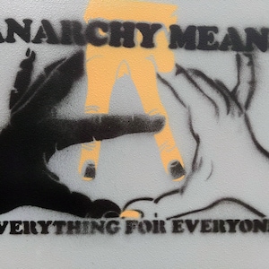 May include: A graphic image with the words "ANARCHY MEANS EVERYTHING FOR EVERYONE." The artwork features two hands, one black and one white, with an orange "A" in the center. The design is a stencil style.