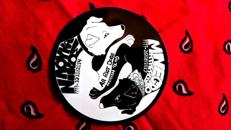 May include: Black and white sticker with two dogs in a yin yang design. The text on the sticker reads "MaveGo Matracco 777-261081/2017" and "Niroka 777-101012014 All Riot Dogs Go To Heaven 888".
