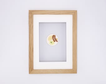 Miniature bratwurst with sauerkraut in a real wooden frame