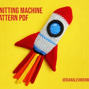 May include: Knitting machine pattern PDF for a red, white, and blue rocket toy with a yellow, orange, and red flame. The pattern is available on Etsy from @dianalevineknits.