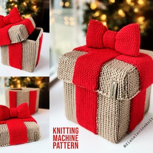 May include: A knitted gift box with a red bow and a beige base. The box is decorated with a red ribbon and has a label that says "Handmade with Love".
