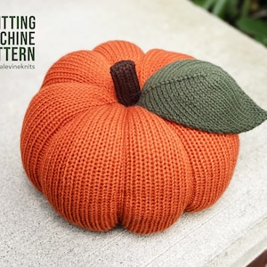 May include: Knitting machine pattern for a pumpkin with a green leaf. The pumpkin is orange and has a brown stem. The pattern is available on the website @dianalevineknits.