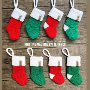 May include: Eight miniature knitted Christmas stockings in red and green with white trim. The stockings have a brown tag with white text that reads "@dianalevineknits KNITTING MACHINE PATTERN PDF".