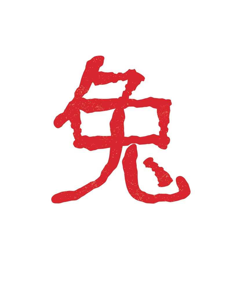 May include: A red Chinese calligraphy symbol, possibly a stamp or print, against a white background. The symbol has a textured, slightly distressed appearance, suggesting it may be a brushstroke or a print.