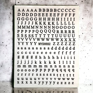May include: A white card with black letters printed in rows from A to Z. The letters are repeated in descending size. The card has the text "MYSW002" printed in the middle.