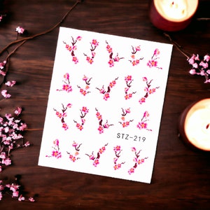 May include: A sheet of nail art stickers with pink and white cherry blossom designs. The sheet has the text "STZ-219" printed on it.