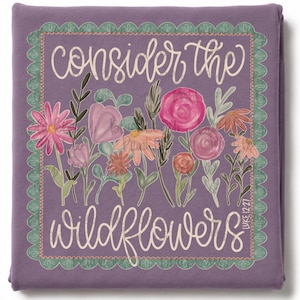 May include: A purple blanket featuring a scalloped green border and a central illustration of various wildflowers in shades of pink, orange, and green. The text "consider the wildflowers" and "LUKE 12:27" is printed in a white cursive script.