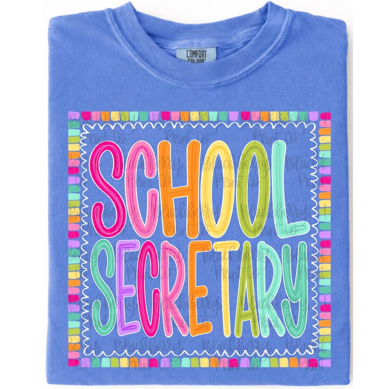 May include: A periwinkle blue t-shirt featuring a colorful graphic print with the text SCHOOL SECRETARY in bright pink, orange, yellow, and green letters. The text is enclosed within a decorative border made of small, multicolored rectangular blocks.