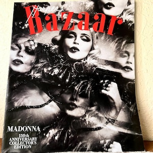 May include: A black and white cover of Harper's Bazaar magazine featuring Madonna. The magazine cover has the word "Bazaar" in large red letters. The cover also includes the text "Madonna 150th Anniversary Collector's Edition".