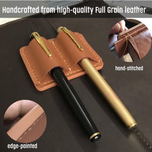 May include: Handcrafted from high-quality Full Grain leather. A brown leather pen holder with two pens, one black and one gold. The pen holder is hand-stitched and edge-painted. The text "Handcrafted from high-quality Full Grain leather" is at the top.
