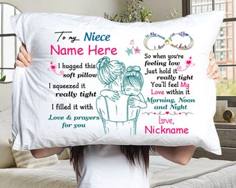 May include: White pillow with a message for a niece. The message reads "To my Niece Name Here I hugged this soft pillow I squeezed it really tight I filled it with Love & prayers for you" and "to the moon and back I love you So when you're feeling low Just hold it really tight You'll feel My Love within it Morning, Noon and Night Love, Nickname". The pillow features a drawing of two women hugging.