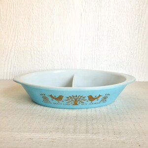 May include: A vintage, oval-shaped divided serving dish. The dish is light blue with a white interior and features a gold tree and bird design with the text "HAVING DON'T LAST BUT COOKERY IN".