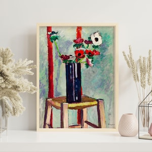 May include: A framed painting of a still life featuring a dark blue vase filled with red and white flowers. The vase sits on a wooden stool against a backdrop of red stripes and a light blue and green background. The artwork is in a wooden frame.