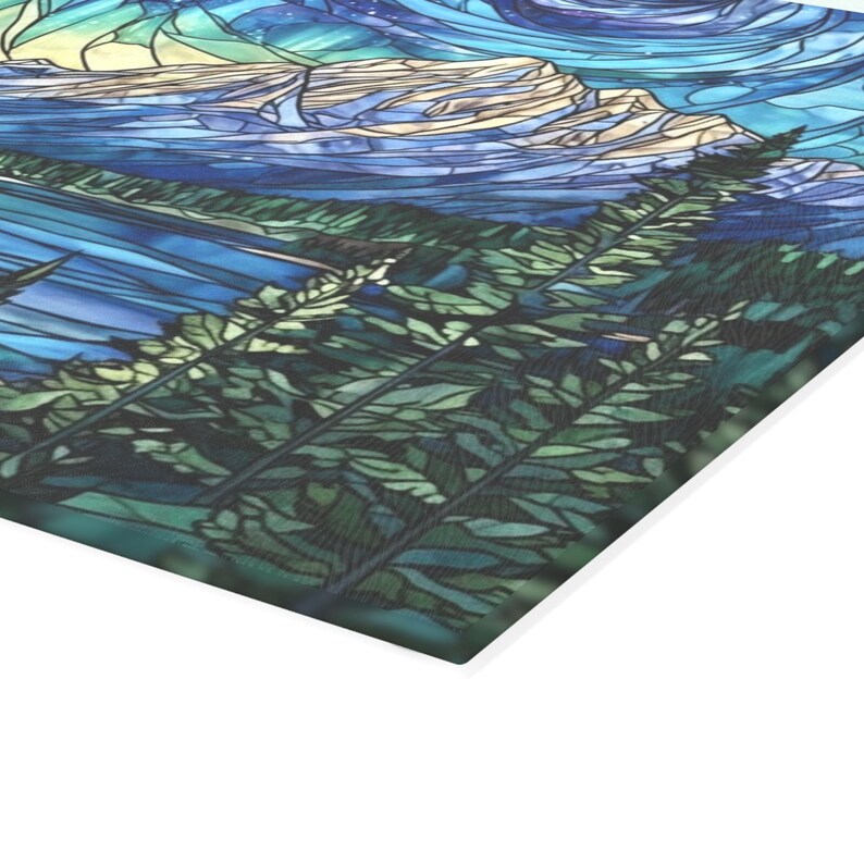 Close-up of stained glass style mountain and night sky artwork on tempered glass